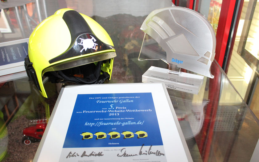 Einer von den drei (echten) Helmen, die Siegerurkunde Urkunde und ein wunderschöner Pokal für unseren 5. Platz beim Dräger Feuerwehr-Website-Wettbewerb 2013